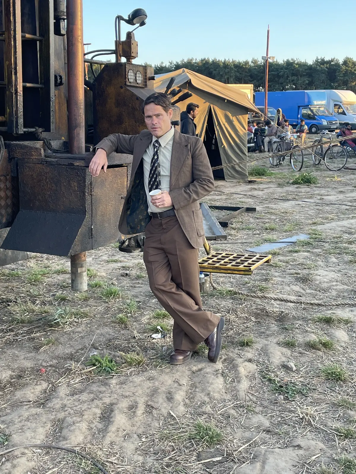 Alex Reece in costume as the British Engineer beside mining machinery